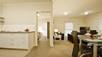 Ein modernes Hotelzimmer mit Küche, Essbereich und separatem Wohnbereich.