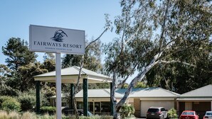 A sign for Fairways Resort, part of the Rosebud Country Club, with a covered outdoor area and parked cars. - Fairways Resort (Rosebud)