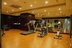 A gym with treadmills, elliptical machines, and a stationary bike. - Minerva Grand Kondapur (Hyderabad)