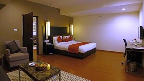 Una habitación de hotel con cama, escritorio, silla y mesa de centro.