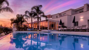 Een buitenzwembad en ligstoelen