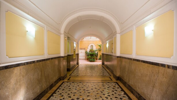 A corridor with a tiled floor, white walls, and an arched ceiling. - Residenza Sistina (Rome)