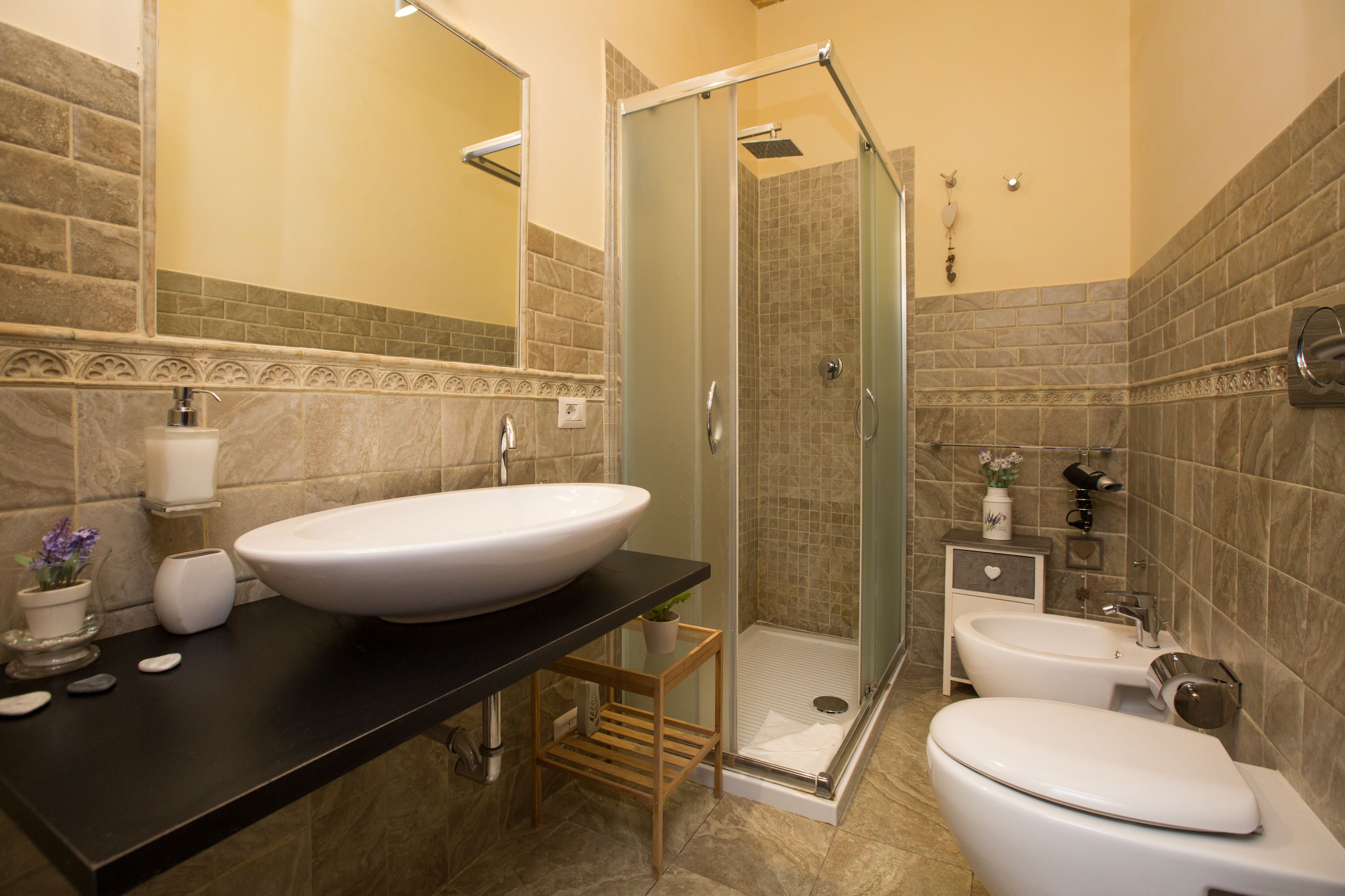 A bathroom with a large sink, toilet, and shower.