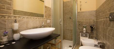 A bathroom with a large sink, toilet, and shower.
