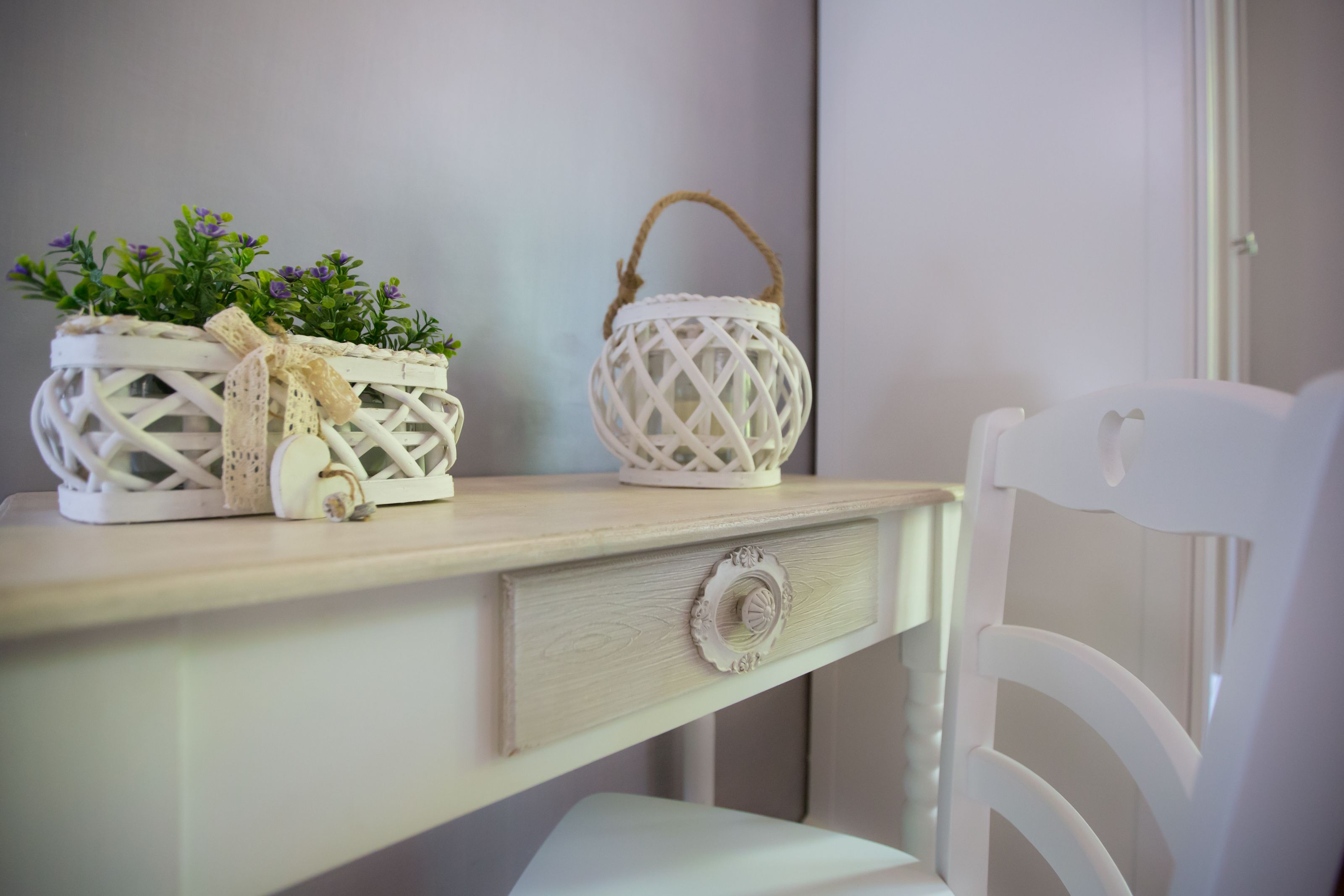 A white chair and a wooden table with two white decorative items on it.