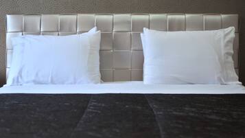 A neatly made bed with a tufted headboard and two pillows.