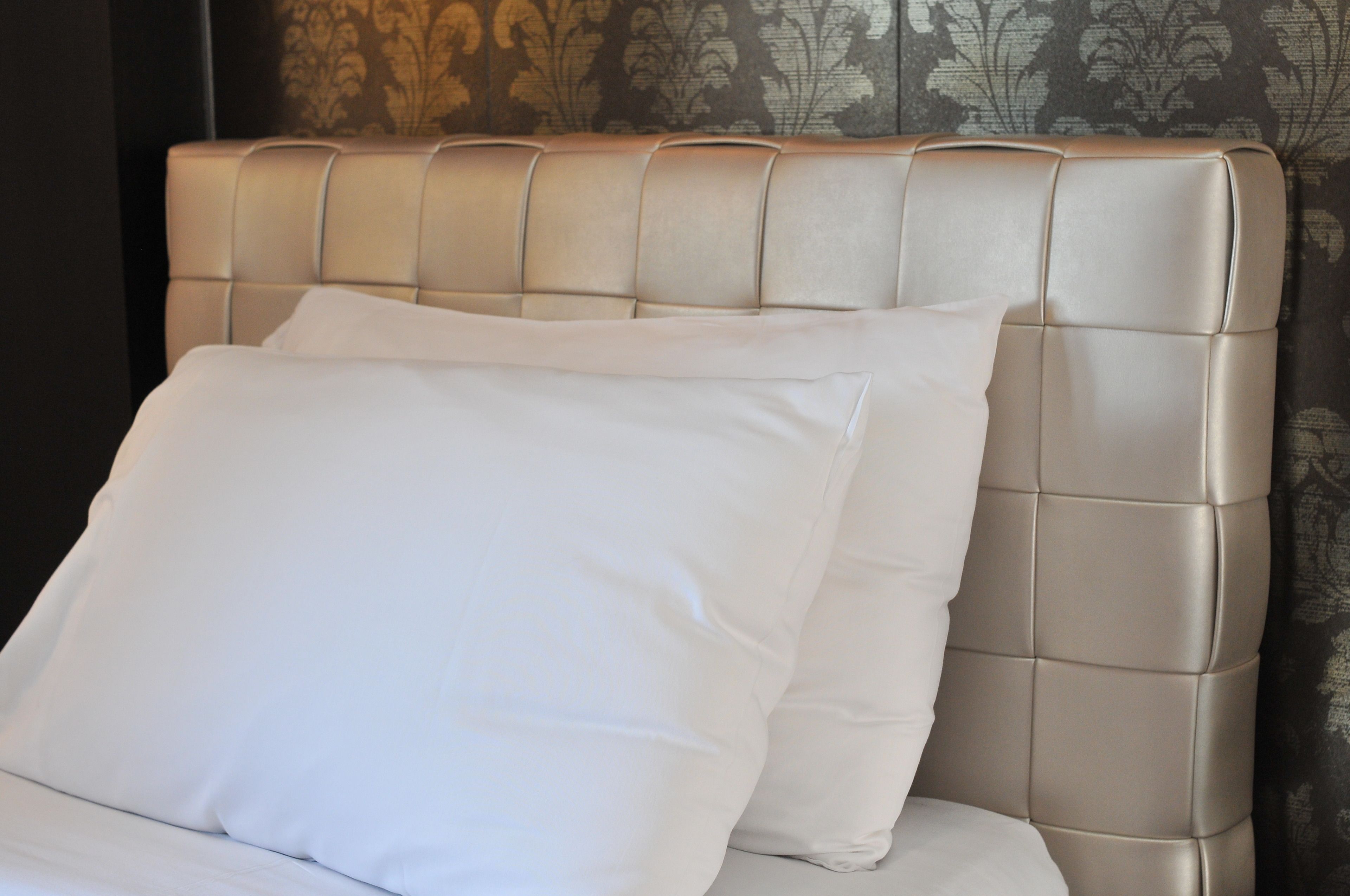 A bed with a tufted headboard and white bedding.