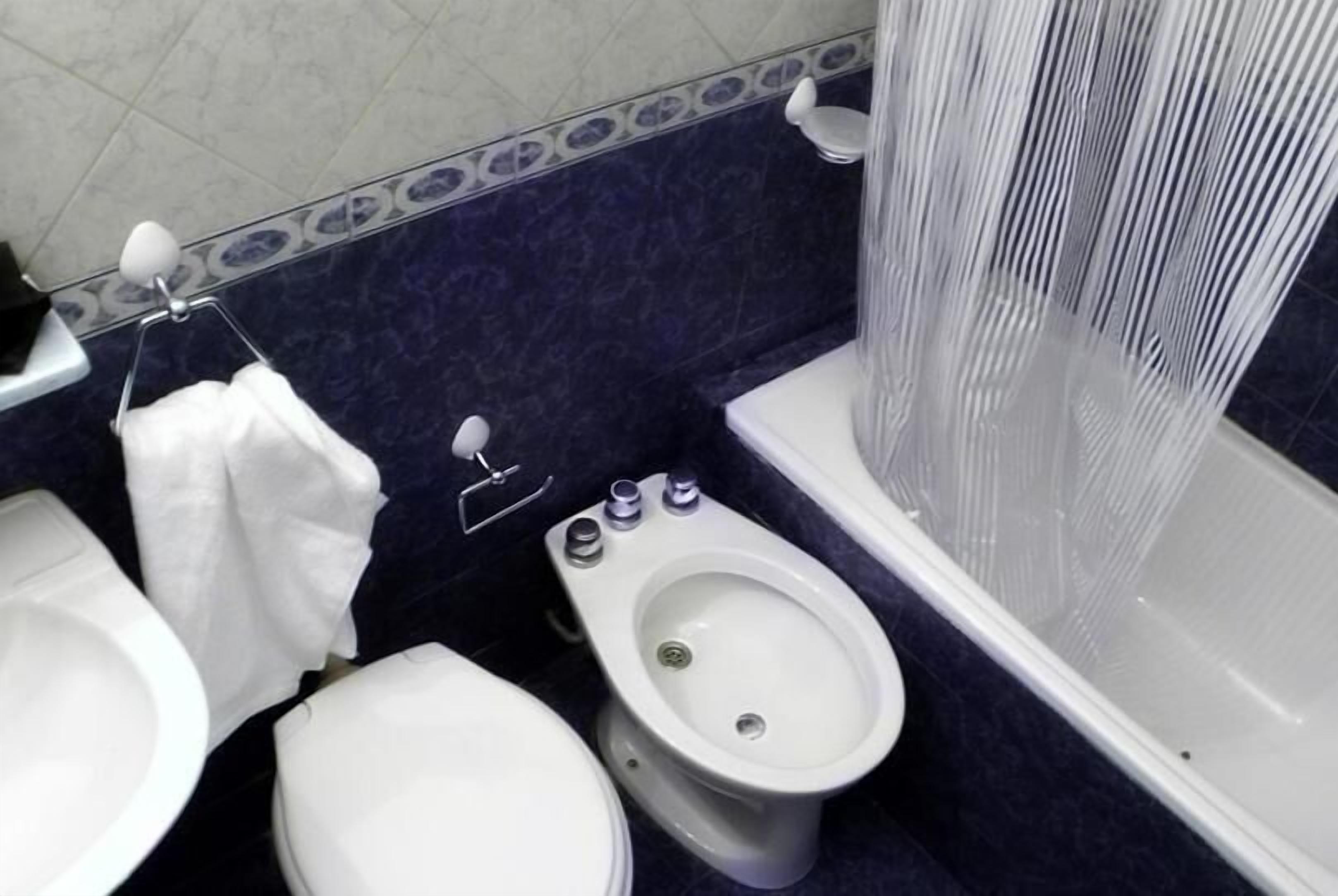 A bathroom with a toilet, bidet, and bathtub.