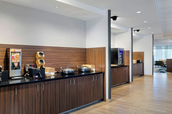 Une cuisine moderne avec des meubles en bois, une machine à café et un four à micro-ondes.