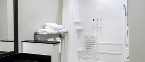 Een moderne badkamer met een zwart wastafel, een wit bad en een douchegordijn.