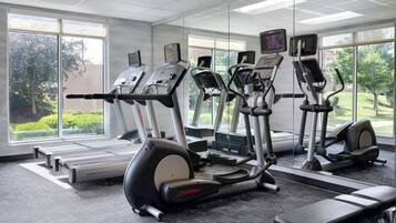 Une salle de sport équipée de tapis de course, d’elliptiques et d’un vélo d’appartement.