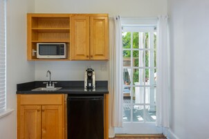 Una cocina con armarios de madera, microondas, cafetera y lavavajillas.