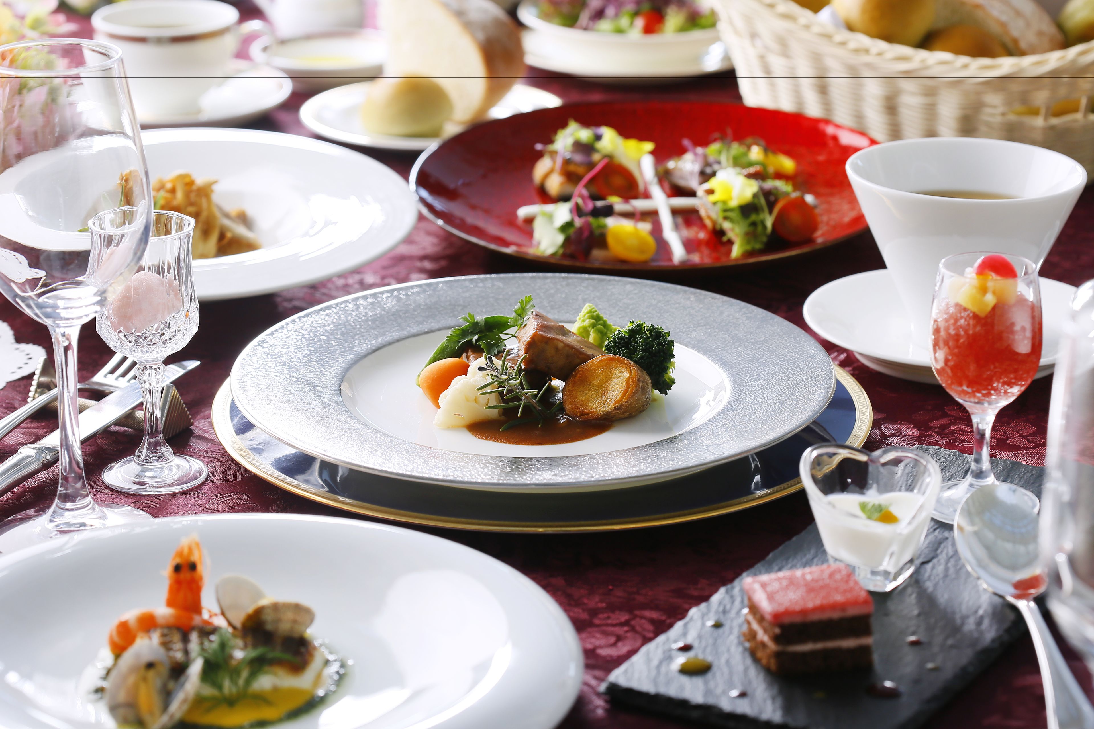 A table set with various dishes, including seafood, vegetables, and desserts, suggesting a fine dining experience.