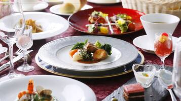 A table set with various dishes, including seafood, vegetables, and desserts, suggesting a fine dining experience.