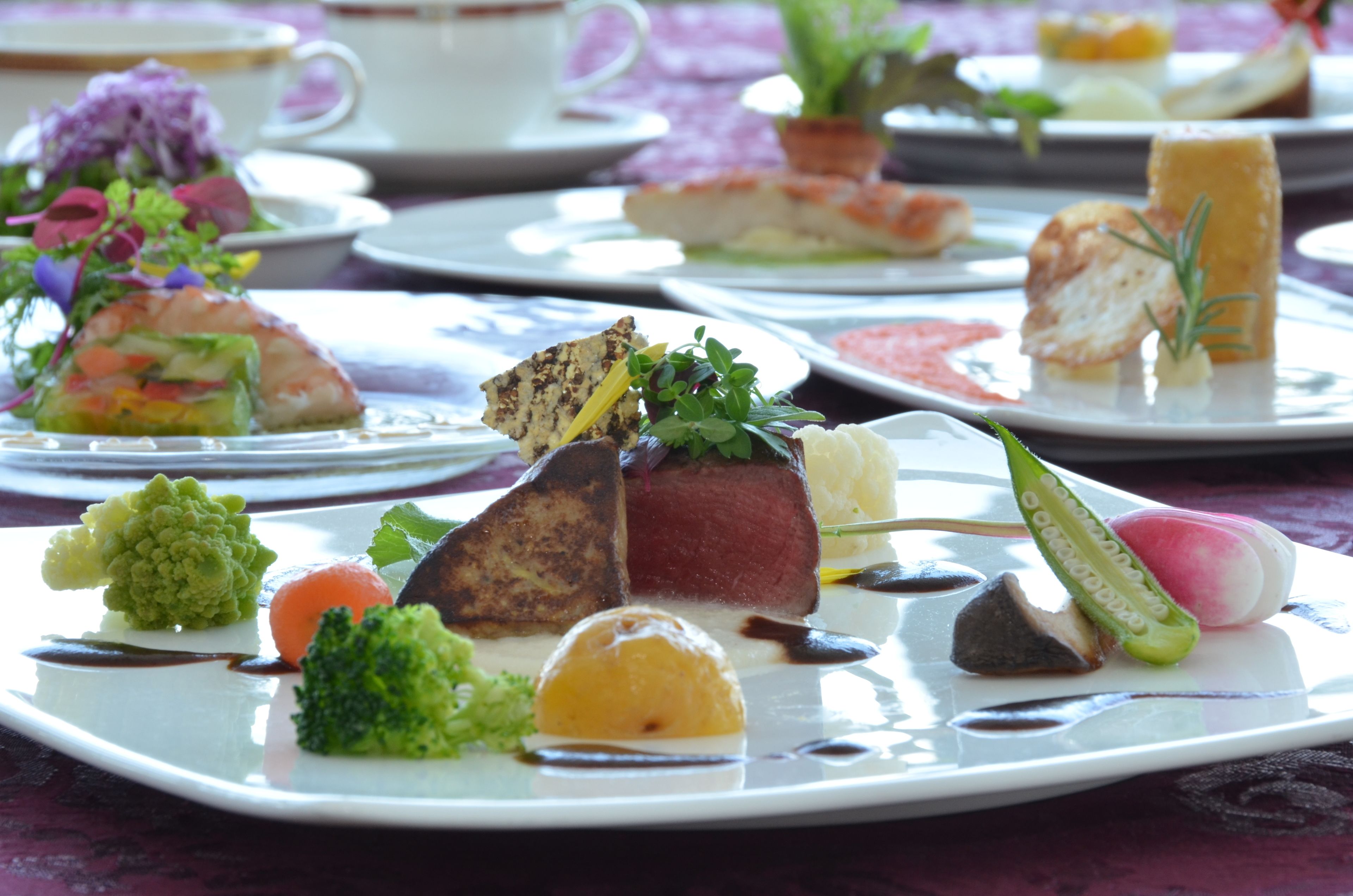 Diversos platos emplatados con diferentes alimentos y guarniciones.