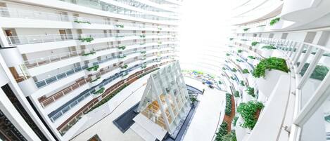 A multi-level atrium with a central open space, surrounded by balconies with greenery.