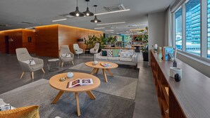 A modern lobby with seating areas, a reception desk, and a view of the city. - City Express Plus by Marriott Ciudad de México Santa Fe (Mexico City)