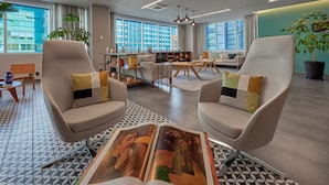 A modern hotel lobby with two armchairs, a coffee table, and a large open space. - City Express Plus by Marriott Ciudad de México Santa Fe (Mexico City)
