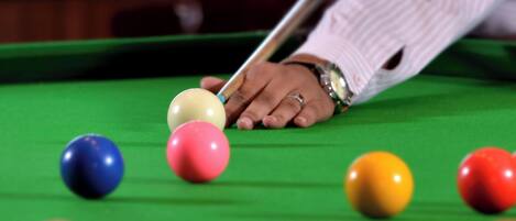 A pool table with balls and a cue stick.