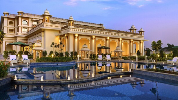 A large, ornate hotel with a reflective pool and multiple lounge areas.
