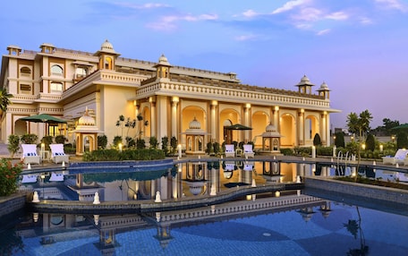 A large, ornate hotel with a reflective pool and multiple lounge areas.