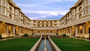 A large, symmetrical courtyard with a central water feature, surrounded by multiple balconies and arched doorways.