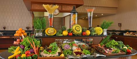 Een buffet met diverse soorten fruit, groenten en bereide gerechten.