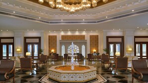 A lobby with a central fountain, seating arrangements, and chandeliers.