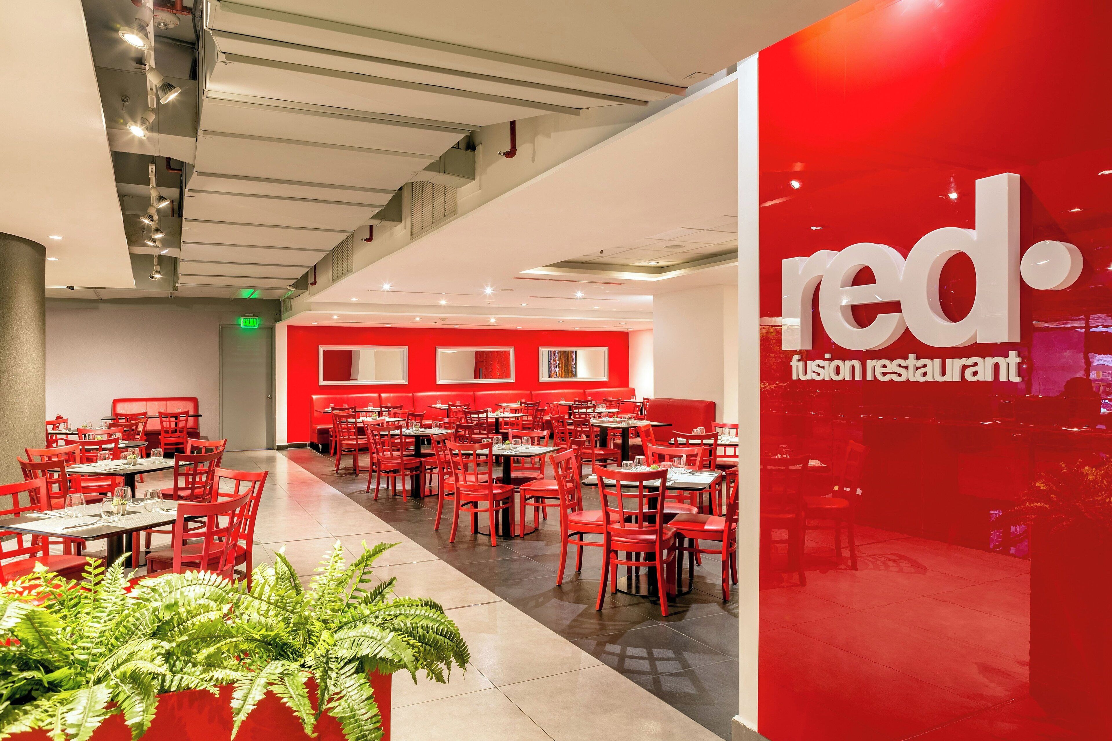 Ein Red Fusion Restaurant mit roten Stühlen und Tischen in einem geräumigen Innenbereich.
