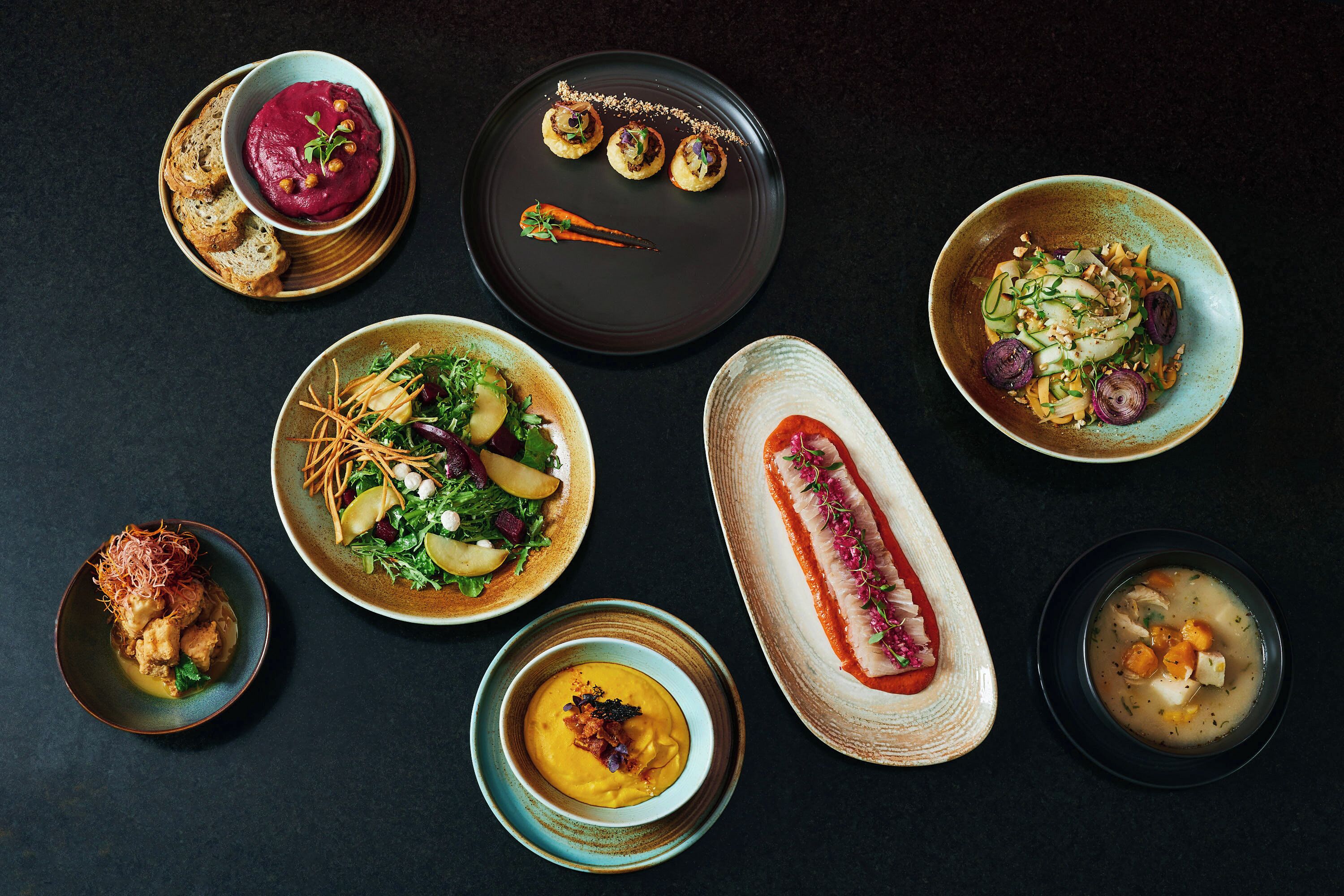 Une variété de plats disposés sur une table sombre.