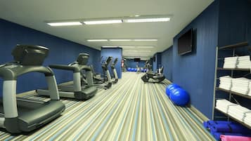 Un gimnasio hotelero con cintas de correr, elípticas y pelotas de ejercicio.