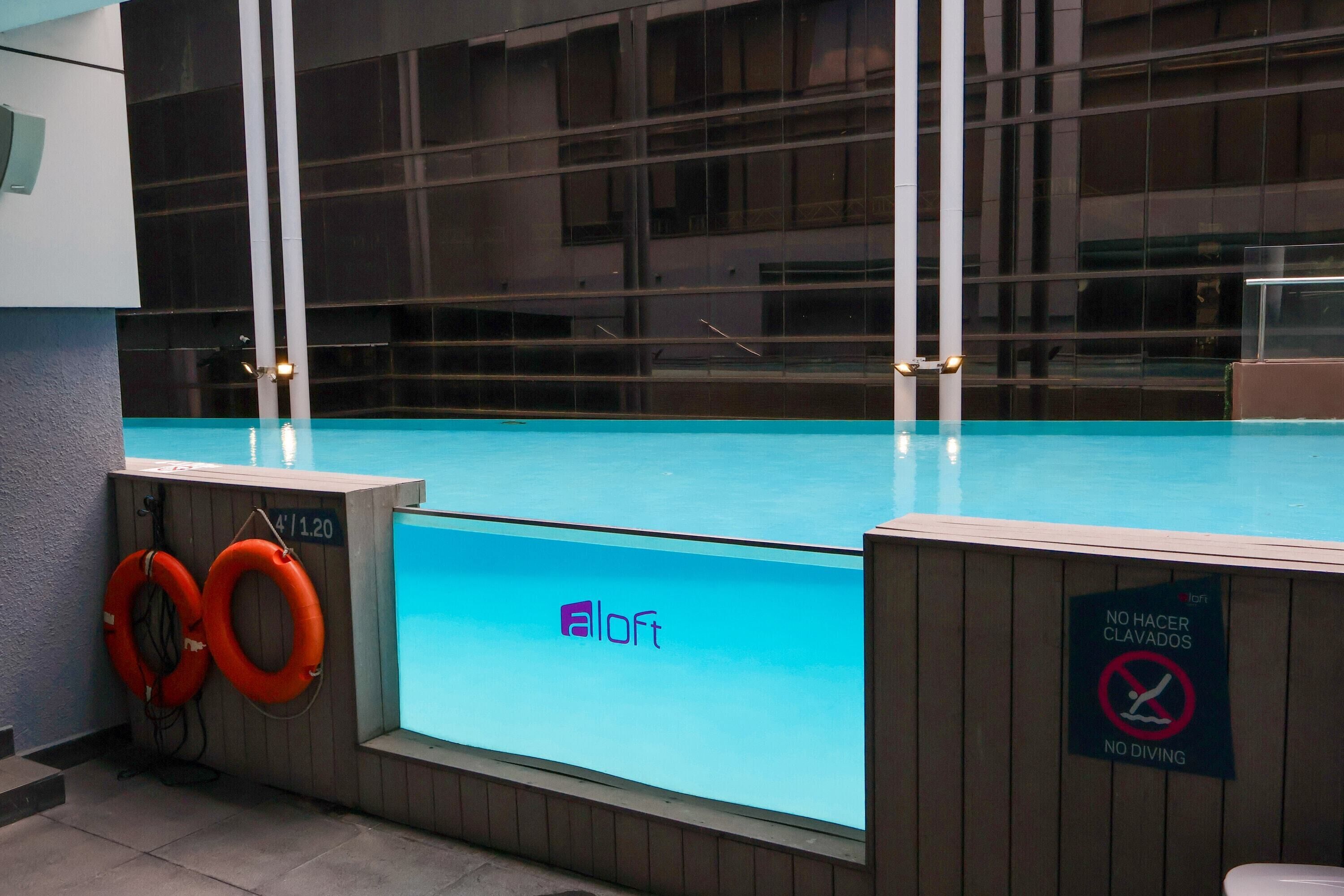 Una piscina con un letrero que indica 'NO DIVING' y 'NO HANGER CLAVADOS'.