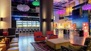 Een moderne lounge met zitplaatsen, een bar en een trap.
