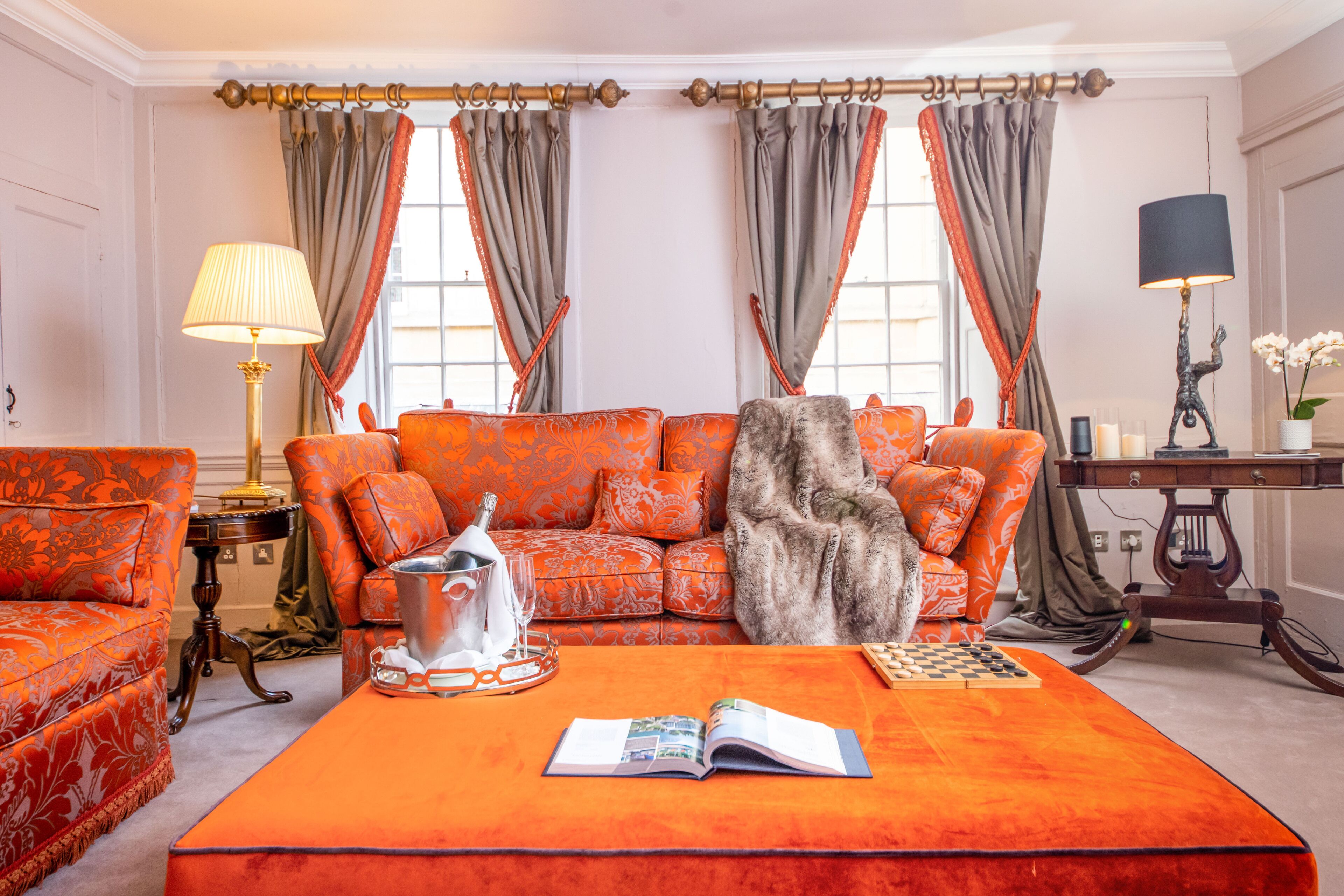 A room with a sofa set, a coffee table with a book, a lamp, and a chessboard.