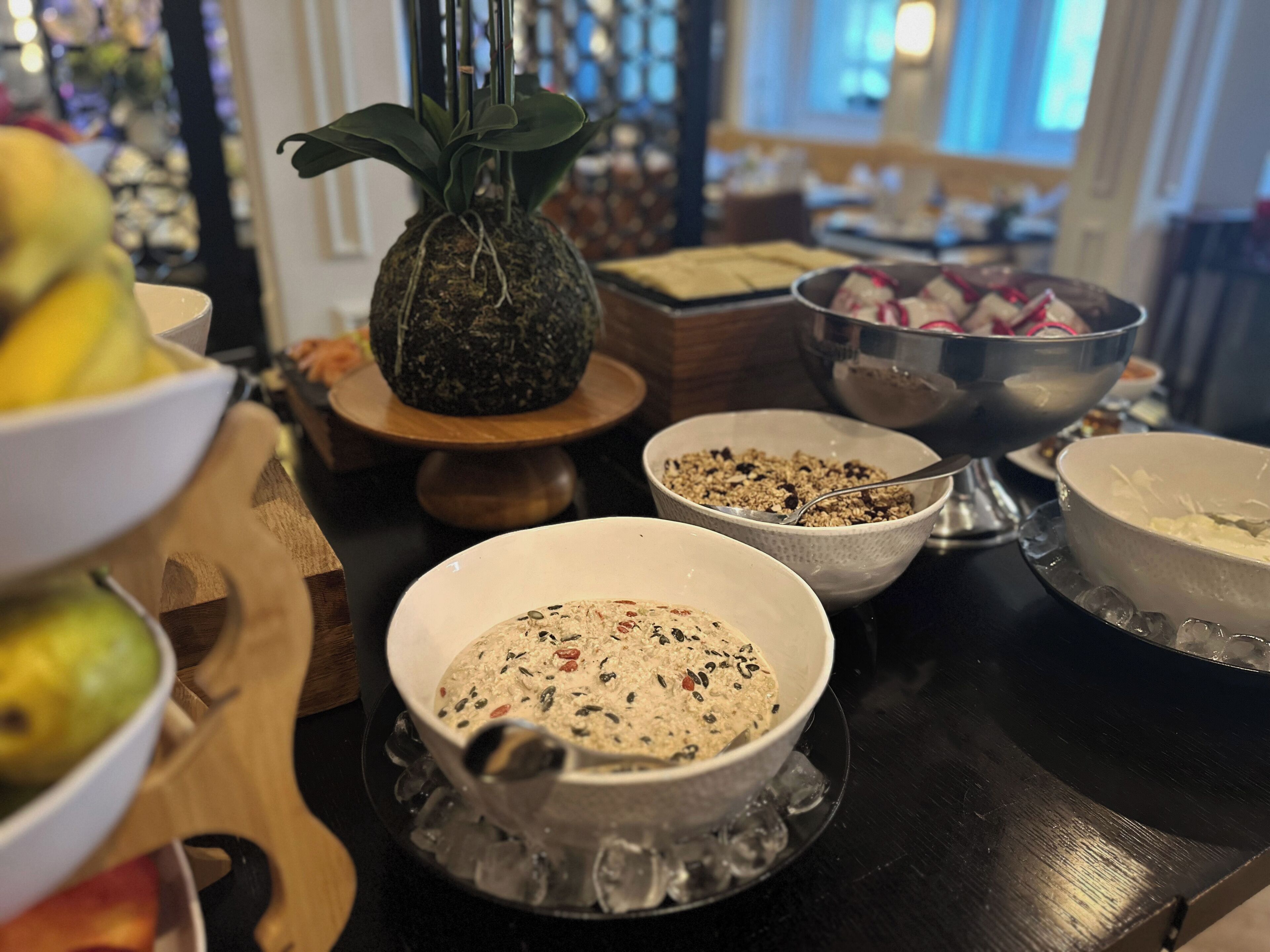 Una mesa de comedor con diversos platos, incluyendo un tazón de ensalada, un tazón de avena y un tazón de sopa. También hay una decoración de piña sobre la mesa.