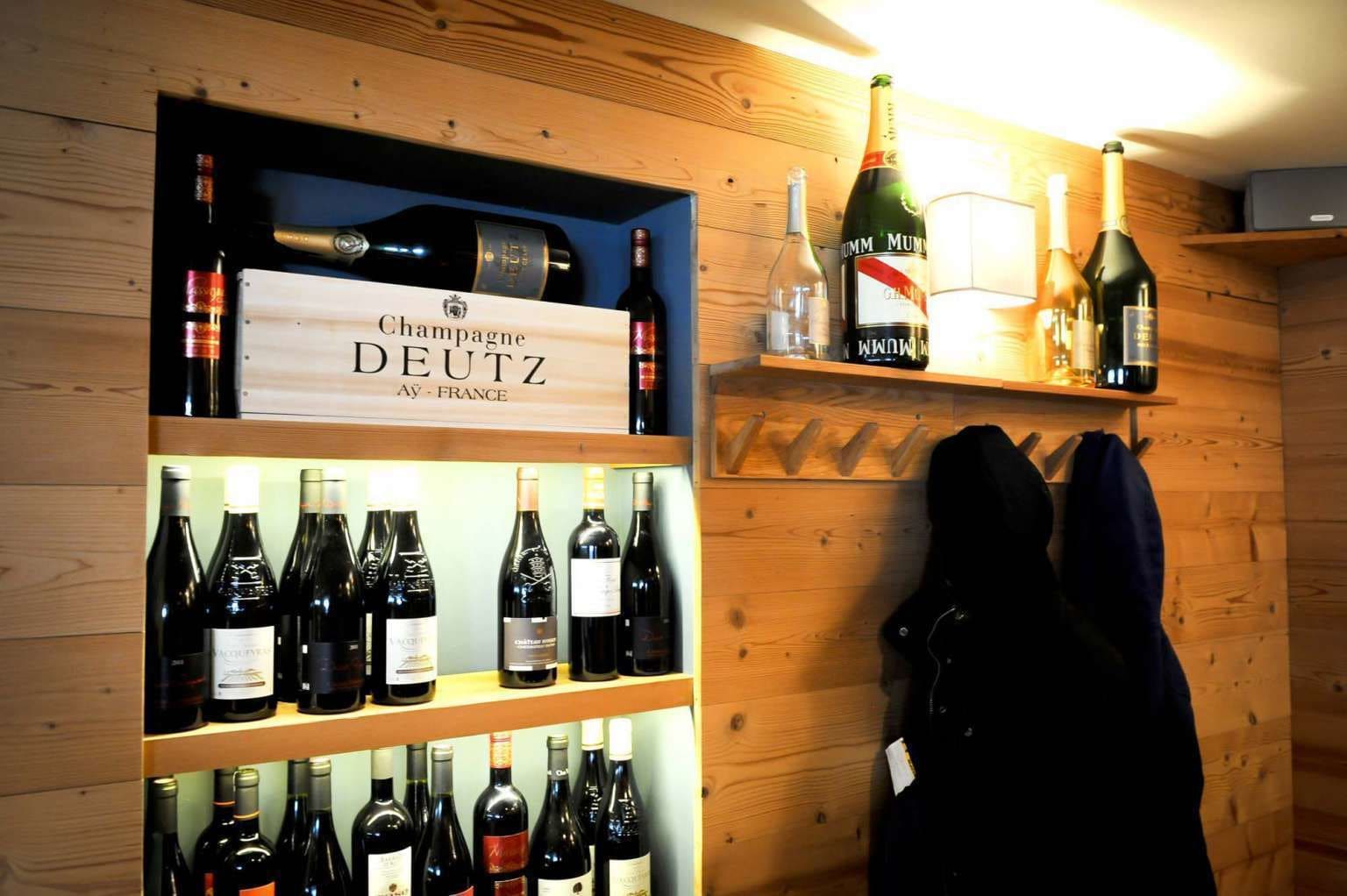 Una bodega con estantes llenos de botellas de vino y un cartel que dice 'Champagne DEUTZ AÜF - FRANCE'.