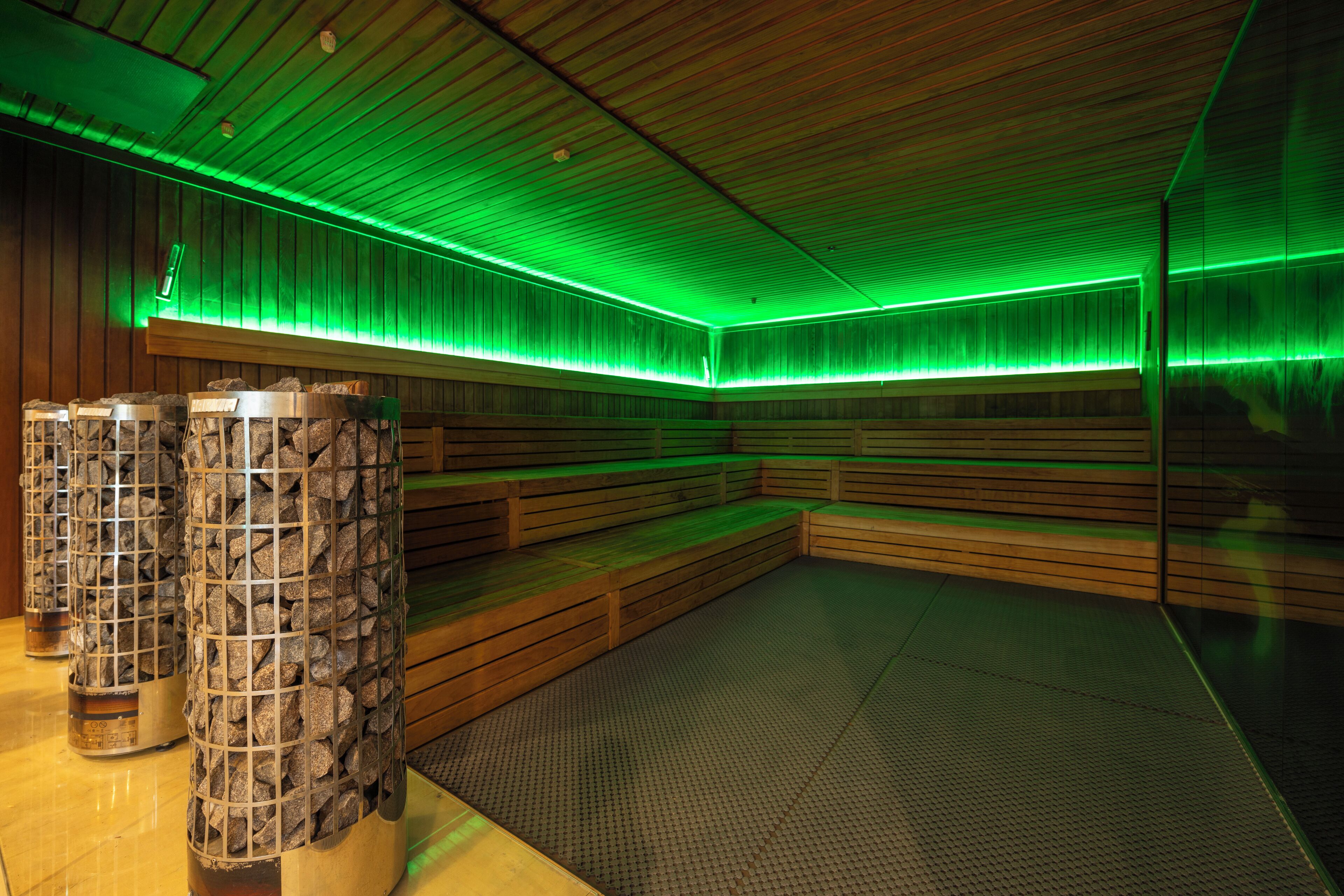 Een sauna met houten banken en een betegelde vloer.