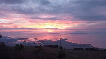 A sunset over a coastal landscape with a cable car system.