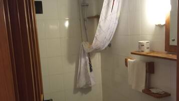 Baño con ducha, inodoro y lavamanos.