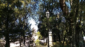 A park pathway with a statue, benches, and a lamppost. - Hotel Edelweiss (Erice)