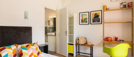 A bedroom with a bed, a desk, a chair, and a wardrobe.
