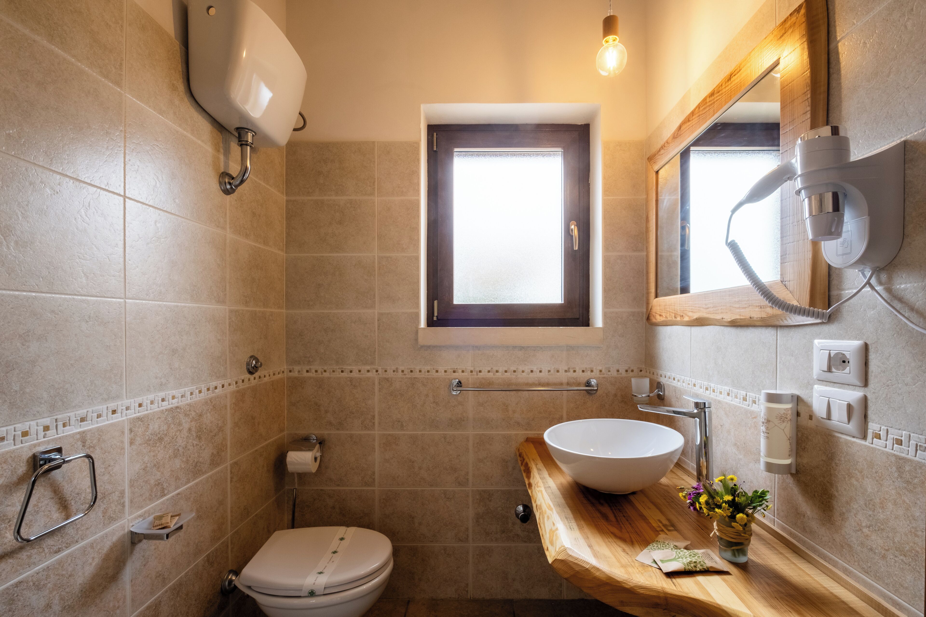 Ein Badezimmer mit Toilette, Waschbecken und einem Fenster.