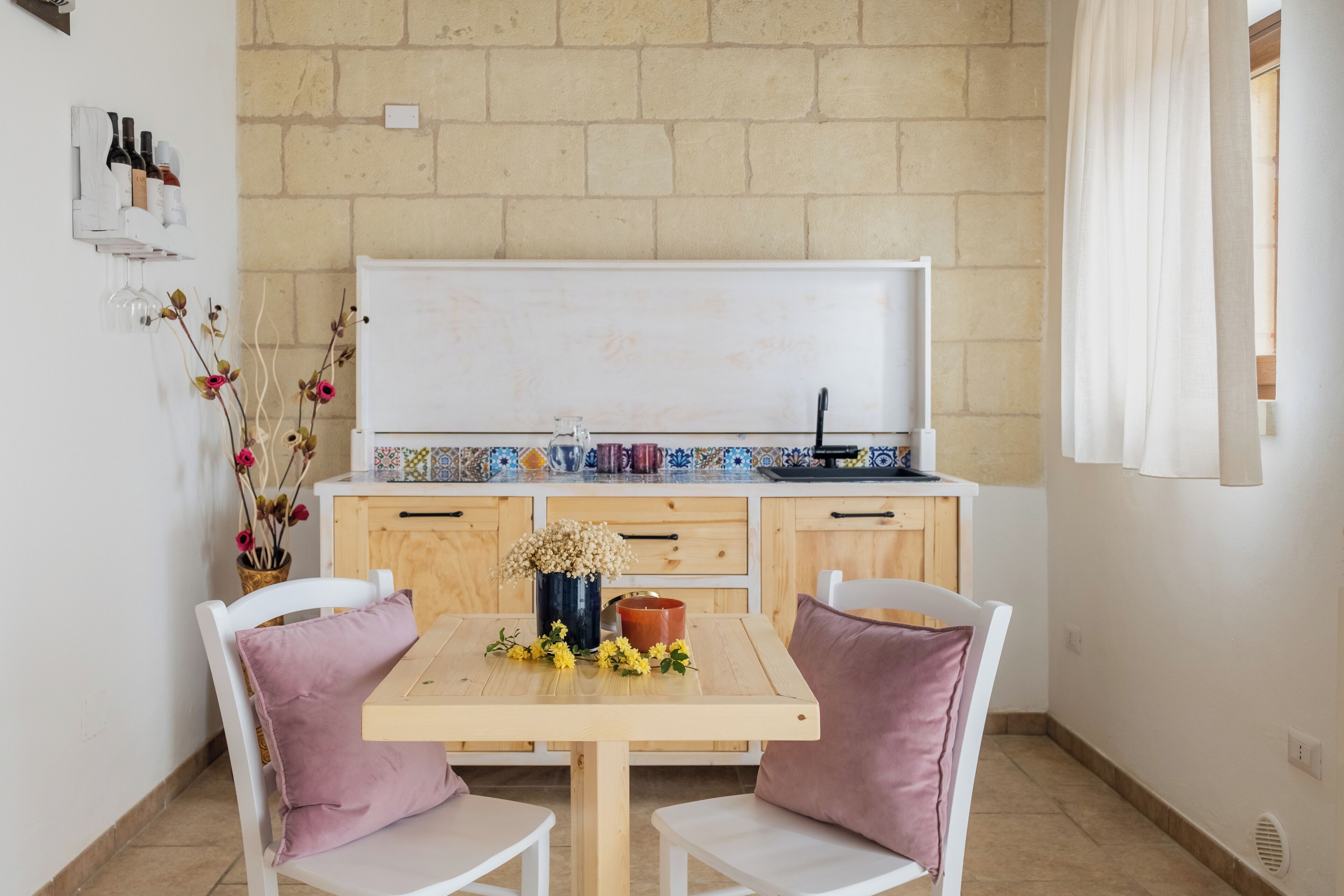 Una cocina pequeña con una pizarra, armarios de madera y salpicadero de azulejos.