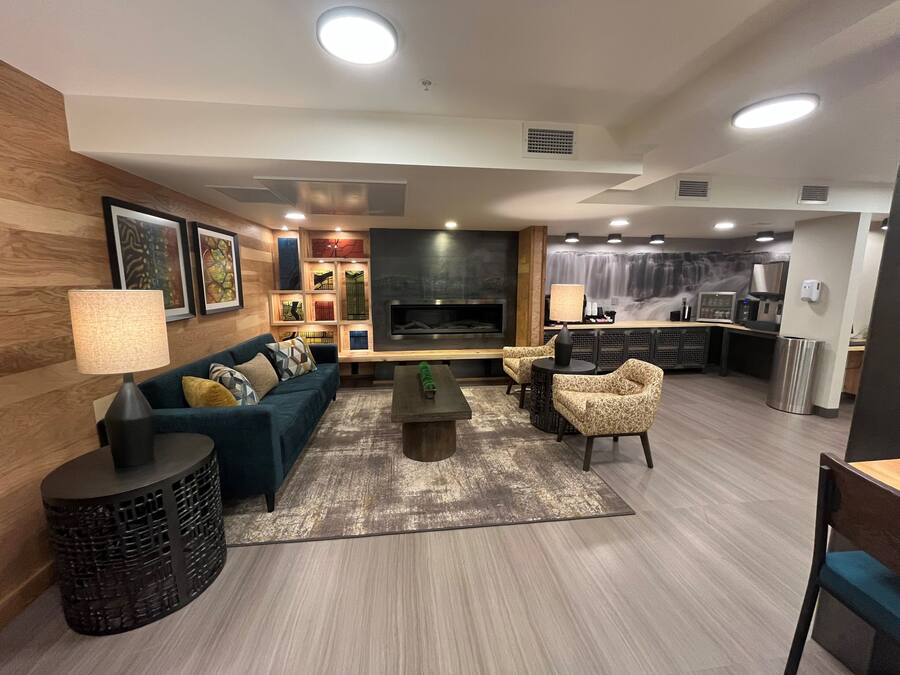 Uma sala de estar moderna com sofá, poltronas, mesa de centro e lareira.