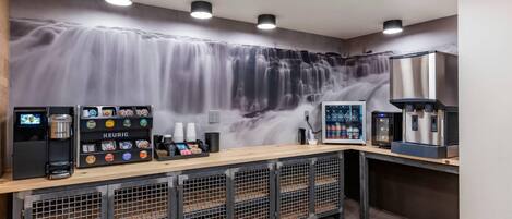 A modern coffee station with a waterfall mural, a Keurig coffee machine, and a water dispenser.