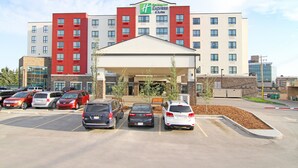A hotel with a central entrance, multiple parking spaces, and a clear sky. - Holiday Inn Express & Suites Calgary NW - University Area by IHG (Calgary)