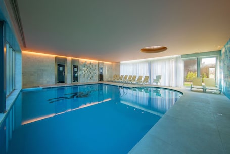 Piscina interna, espreguiçadeiras. HD Duecitânia Design Hotel