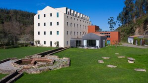 A modern building with a courtyard, stone pathway, and a small water feature. - HD Duecitânia Design Hotel (Penela)