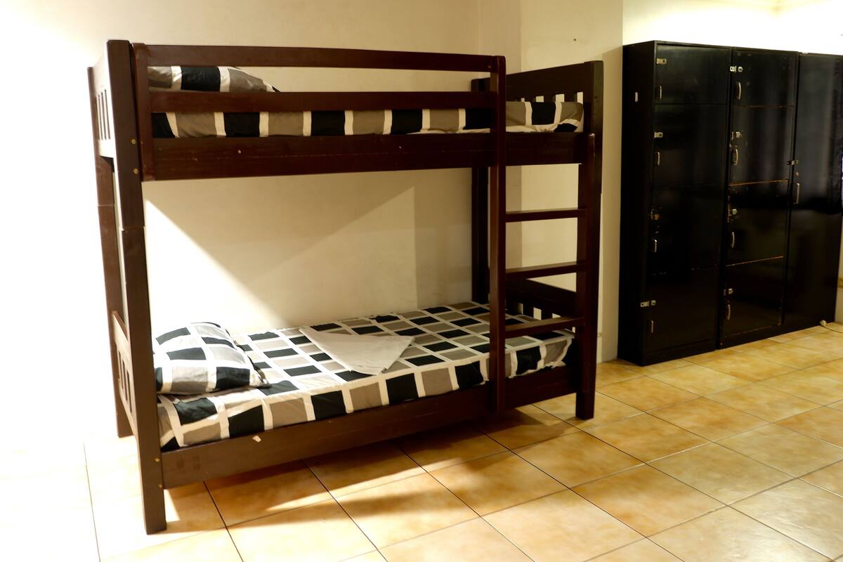 A bunk bed with a checkered mattress and a wooden frame.