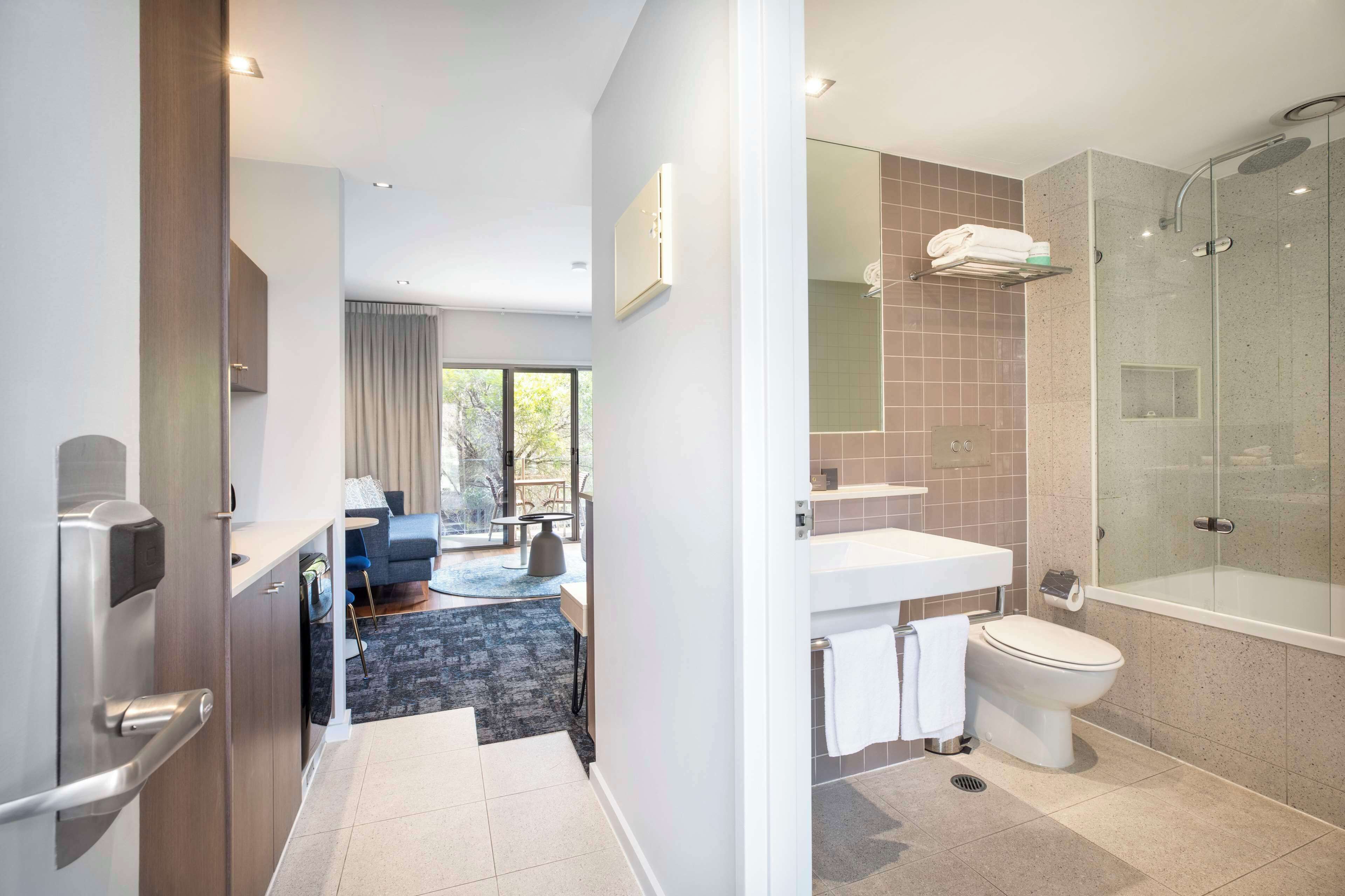 Un baño moderno con ducha envuelta en vidrio, inodoro y lavamanos.